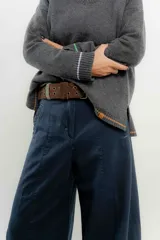 Sweater de punto gris con cuello en V y ribetes en contraste.