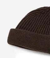 Gorro corto tipo beanie color beige, tejido en lana acrílica con textura acanalada.