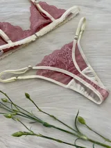 Conjunto de lencería color rosa champagne, con corpiño triangular de encaje y tanga a juego con detalles de encaje.