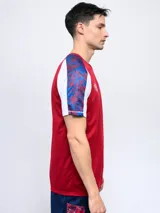 Remera de entrenamiento azul marino con detalles en blanco y rojo en los hombros y mangas. Incluye el logo de Umbro y el escudo del Club Nacional de Football en el pecho.