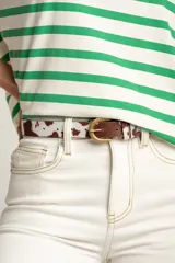 Cinto de cuero con estampado de vaca y hebilla dorada.