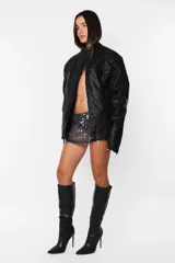 Campera de cuero sintético negro, corte oversize, cuello mao con broche, cierre metálico frontal, bolsillos con cierre, hombreras matelaseadas, puños con cierre y forro matelaseado.