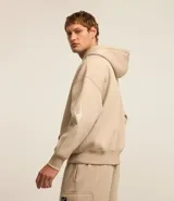 Saco beige de algodón y poliéster con capucha, bolsillo canguro, manga larga ajustada con estampa de llamas lateral, bajo ajustado y estampa lettering localizada.