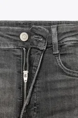 Jeans skinny de tiro alto en denim azul oscuro, con cinco bolsillos y cierre frontal con cremallera y botón metálico.