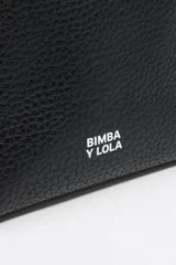 Bolso de mano mediano marca Bimba y Lola, color naranja, confeccionado en cuero con textura granulada. Tiene doble asa corta, correa bandolera ajustable y extraíble, logo estampado en el frente y herrajes plateados. El interior cuenta con etiqueta de tejido con el logo de la marca.