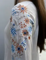 Blusa azul con escote redondo, mangas 3/4 con bordado floral y abertura central con botones. Marca Forgotten Grace.