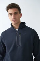 Buzo polar de algodón color bordó, con cuello elevado, medio cierre frontal, bolsillo con cierre en el pecho y logo estampado.