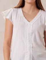 Blusa blanca de tejido pointelle con escote en V y aplique de puntilla en el cuello y mangas cortas con volados.