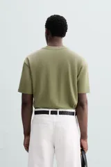 Camiseta blanca de algodón interlock con elasticidad, corte recto, cuello redondo y mangas cortas.