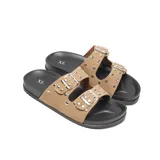 Sandalias de simil gamuza color beige con base negra, dos tiras con hebillas metálicas ajustables y apliques metálicos.