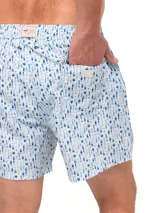 Short de baño celeste con estampado de ballenas en gris y blanco. Tiene cintura elástica con cordón ajustable y bolsillos laterales.