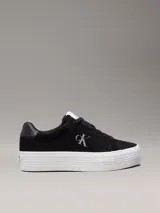 Zapatillas de ante negras con plataforma blanca y logo CK en el lateral.