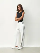 Pantalón blanco de corte ancho con una fina línea negra vertical en los laterales.