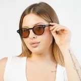 Lentes de sol redondos con montura de carey y lentes verdes.