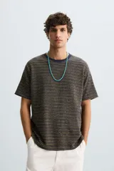 Camiseta de hombre de corte relaxed fit, con cuello redondo y mangas cortas. Diseño a rayas horizontales en tonos negro y dorado.