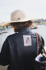 Campera de jean azul oscuro, tipo bomber, con cuello mao y cierre frontal con cremallera.