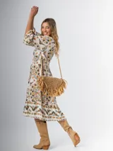Vestido midi de algodón italiano, color blanco con estampado boho chic en tonos naranja, marrón y verde. Tiene corte oversized, mangas 3/4 con volados y cinturón de soga trenzada con hebilla circular.