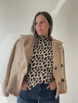 Chaqueta marrón con forro tipo corderito, doble botonadura y cuello con solapas.