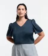 Blusa de crepé color azul petróleo, con escote en V y mangas cortas abullonadas.