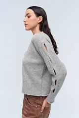Cardigan gris de punto con detalles en los puños y corte estilo cropped.