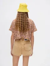 Short de denim color beige con cintura elastizada y cordón ajustable.