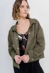 Chaqueta color camel, corte camisa de gamuza con elastano, corte recto abotonado en el frente con botones metálicos y bolsillos grandes en el frente.