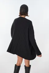 Sweater tejido artesanalmente en Uruguay, color beige con rayas verticales color camel y diseño de trenzas. Tiene bolsillos frontales y puños ajustados.