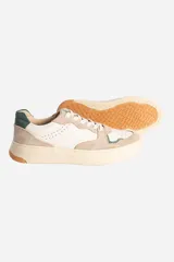Zapatillas urbanas de cuero color blanco y beige con detalles en azul marino.