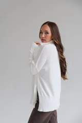 Sweater blanco de corte recto con cuello alto y aberturas laterales.