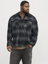 Sobrecamisa de manga larga a cuadros grises y negros, con cuello clásico, cierre frontal con botones y dos bolsillos de parche en el pecho.