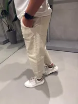 Jean slouchy color arena, de corte holgado y tiro alto, con bolsillos laterales y traseros.