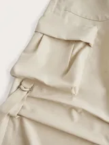 Pantalón cargo color crema de corte amplio con bolsillos laterales y ajuste con cordones en los tobillos.