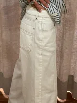 Pantalón ancho de denim con diseño patchwork en diferentes tonos de azul, con tiro alto, corte holgado y cierre frontal con botones.