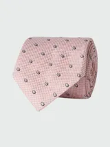 Corbata de seda color rosado claro con microestampado de cuadros y pequeños círculos concéntricos en negro y blanco.