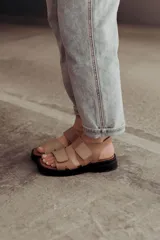 Sandalias color beige con tiras de cuero y ajuste con velcro, con base chunky negra.