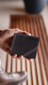 Billetera de cuero marrón oscuro con costuras decorativas en el frente. Interior con visor, tarjeteros y doble compartimento para billetes.