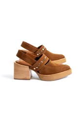 Zapato negro de gamuza con taco de madera y detalle de tachas doradas.