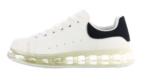 Championes blancos con detalles en negro, acordonados y con suela gruesa.