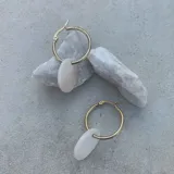 Par de aros tipo argolla dorados con dije colgante de nácar blanco en forma ovalada.