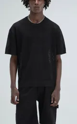 Remera negra de tejido de punto con moldería oversize, confeccionada en viscosa y poliéster. Presenta un diseño de malla con pequeños agujeros y un dobladillo acanalado.
