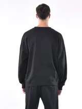 Buzo gris de corte holgado con cuello redondo y mangas largas.