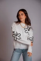 Buzo blanco con diseño gráfico en negro, de corte relajado y detalles en las mangas.