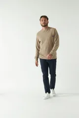 Pantalón chino color beige, corte slim, con bolsillos laterales y traseros.