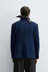 Blazer straight fit color gris claro confeccionada en tejido con viscosa. Cuello con solapas de muesca y manga larga acabada en puño con botón. Bolsillo de vivo en pecho y bolsillos de plastrón en cadera. Bajo con aberturas en espalda. Cierre frontal de botonadura.