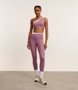 Top deportivo de microfibra color lila con detalle bicolor blanco, hombro único, escote asimétrico y gota vazada.