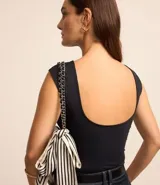 Blusa sin mangas color blanco, con cuello redondo y espalda abierta con escote en U.