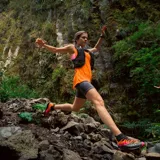 Musculosa deportiva color naranja con logo Merrell estampado en el pecho.