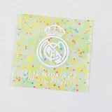 Buzo canguro blanco con capucha y cordones azules. Estampado frontal con el nombre "Real Madrid" en letras de colores y el escudo del club.