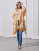 Kimono tejido color naranja con estampado geométrico en blanco y celeste, y terminación con borlas.