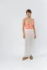 Pantalón blanco de gasa liviana con cintura elástica y aberturas laterales con detalle de pompones.